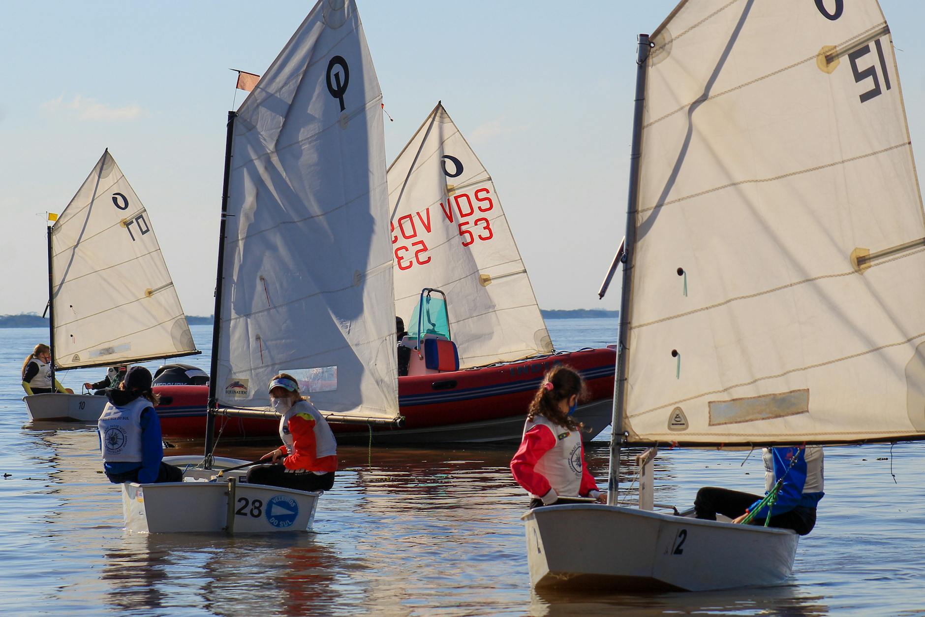 Dzieci żeglujące na małych łódkach podczas słonecznych regat