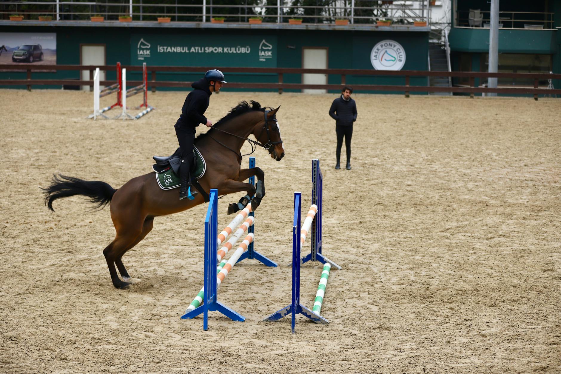 Koń z jeźdźcem skacze przez przeszkodę na parkurze w Stambule