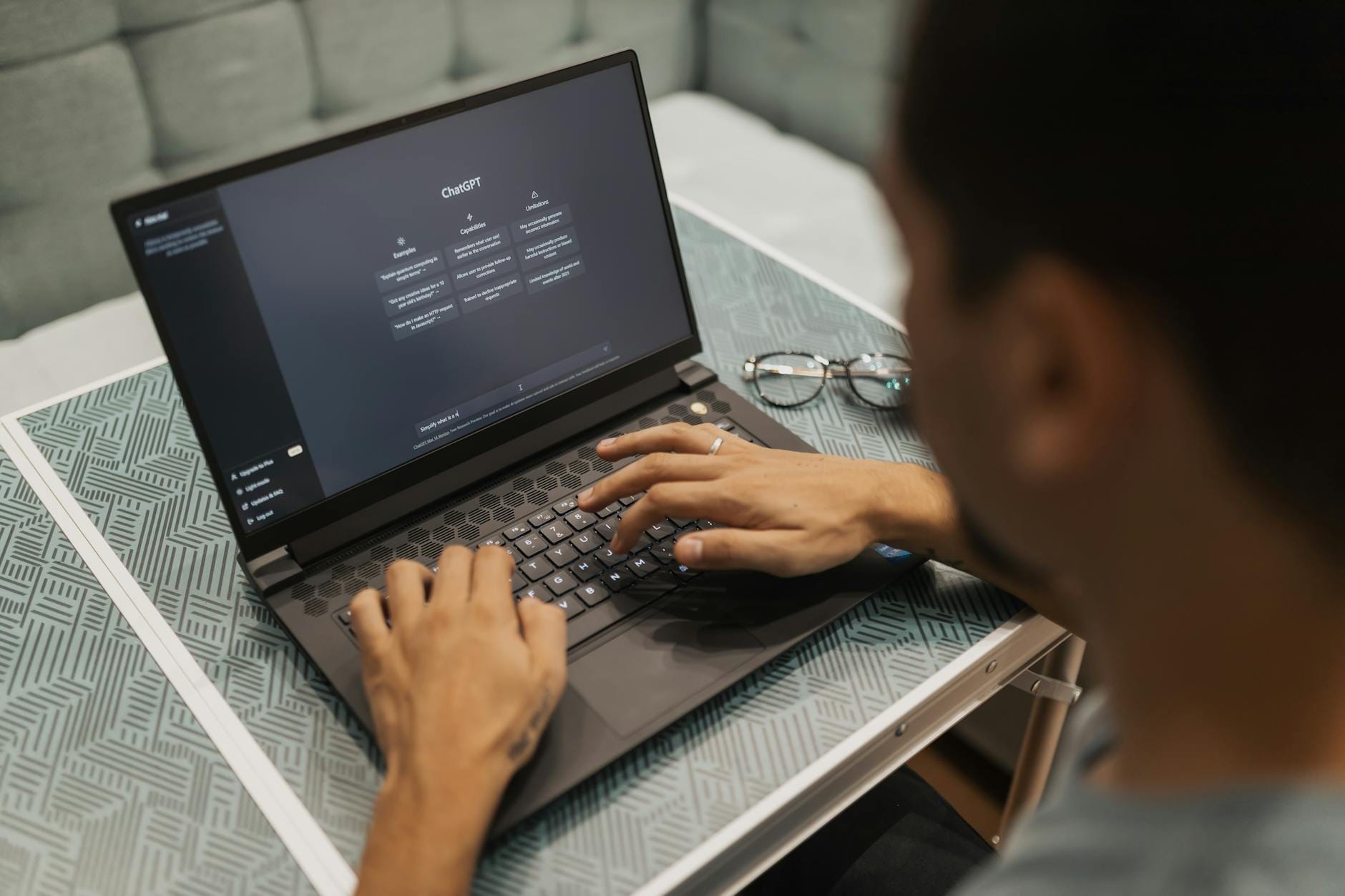 Osoba przy laptopie korzystająca z narzędzi AI w ciągu dnia