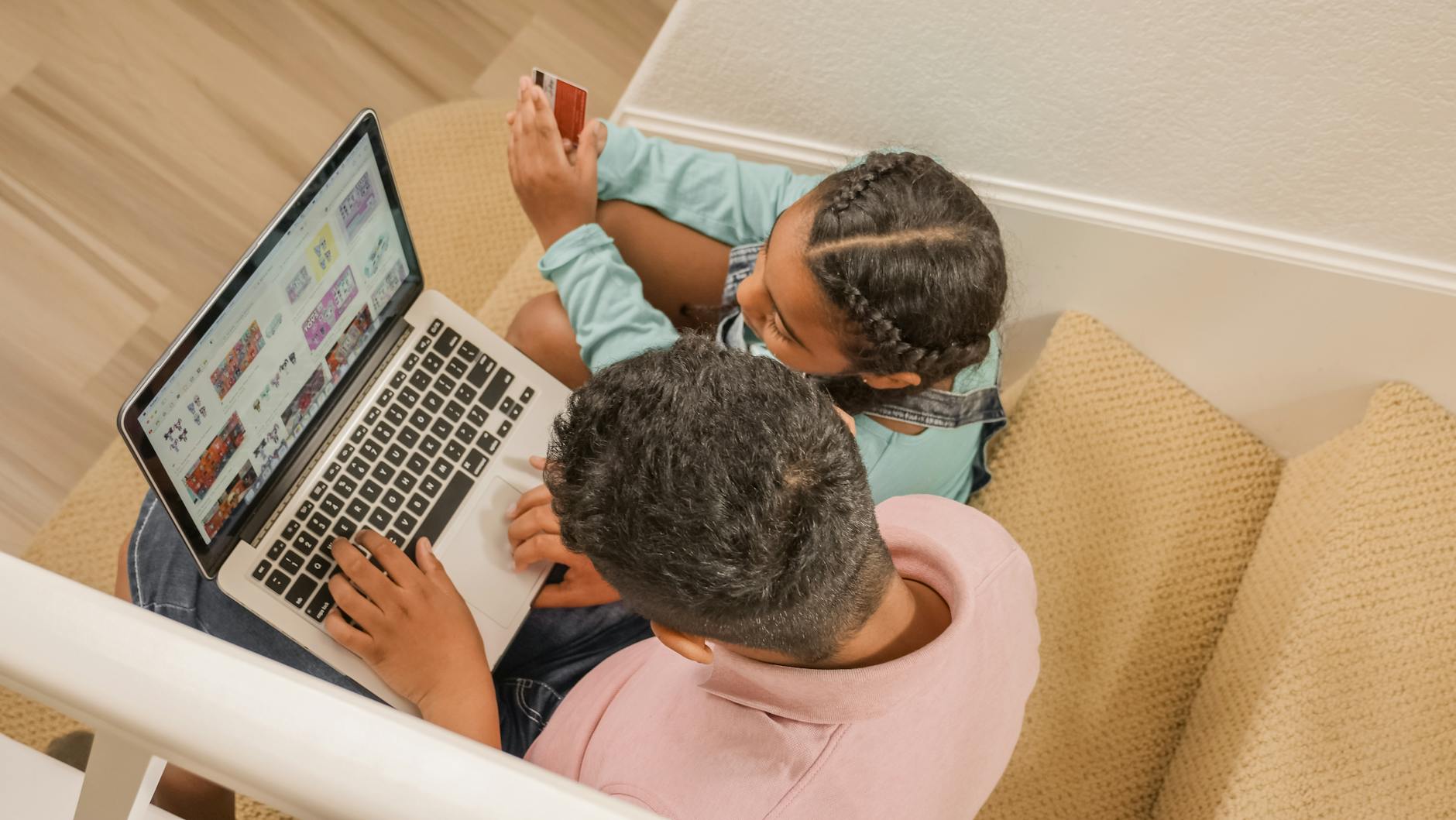 Tata i córka siedzą na schodach z laptopem, ucząc się razem online