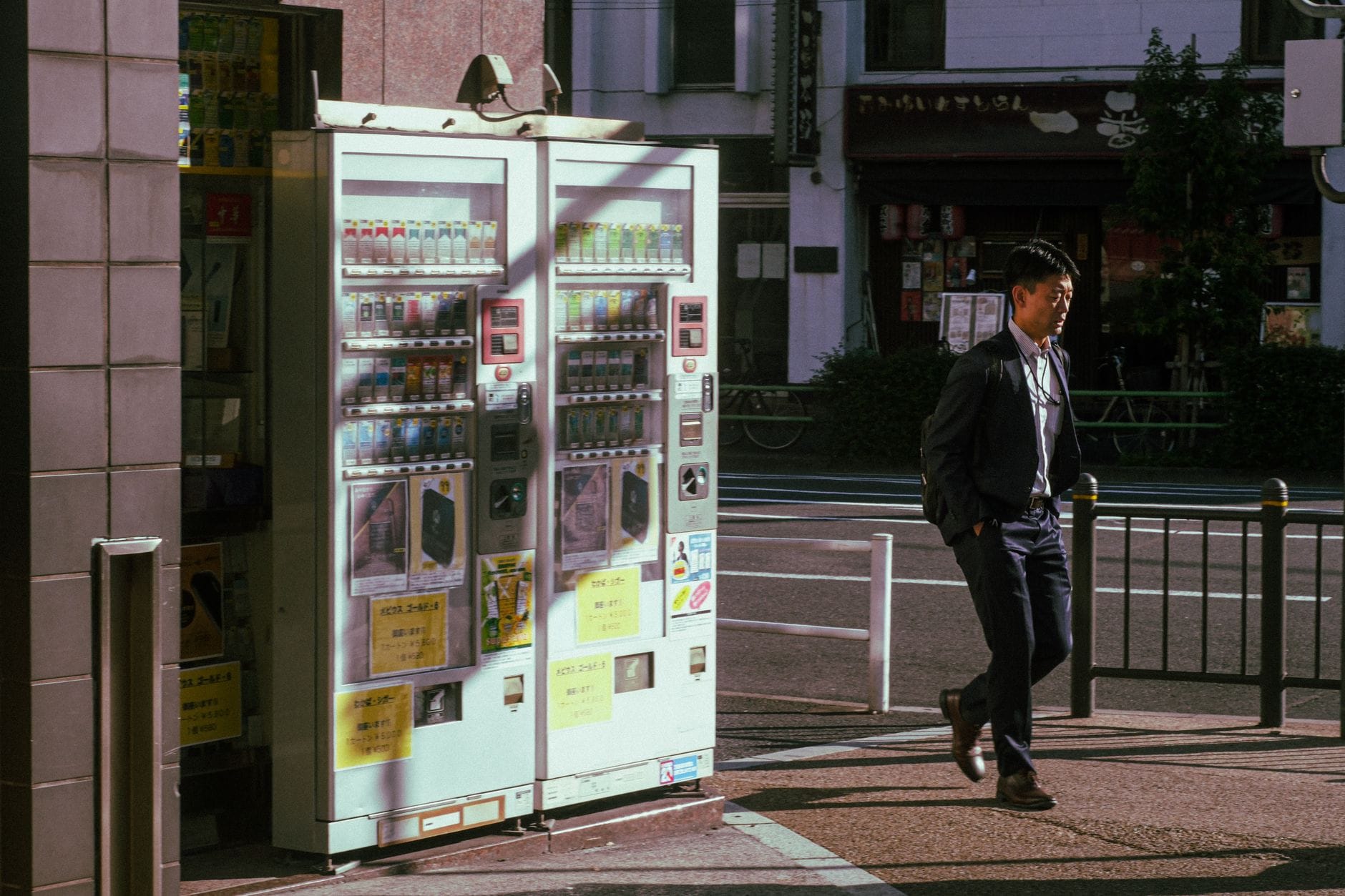 Biznesmen idzie obok automatów sprzedających na ulicy w Tokio