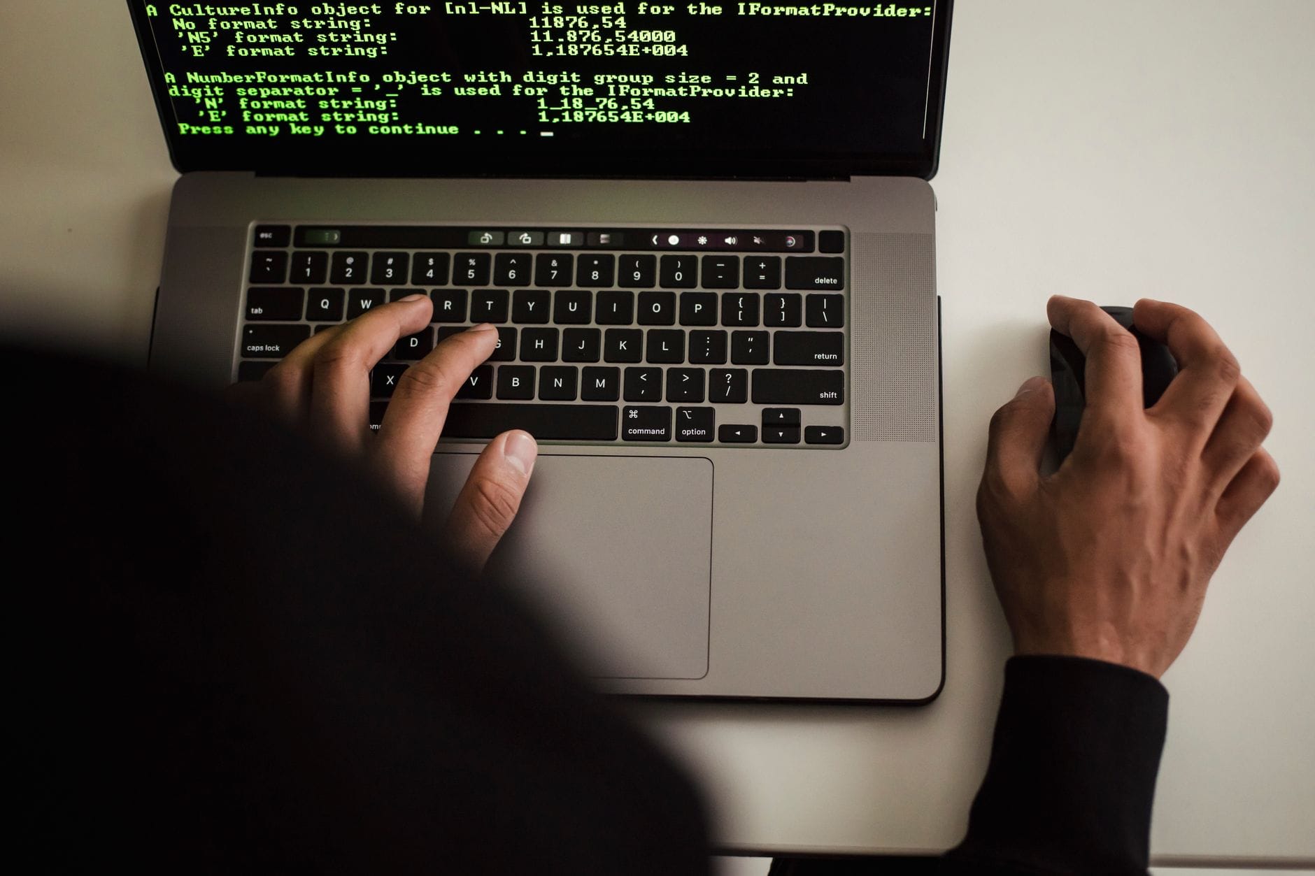 Programista w czarnej bluzie pracuje nad kodem PHP na laptopie