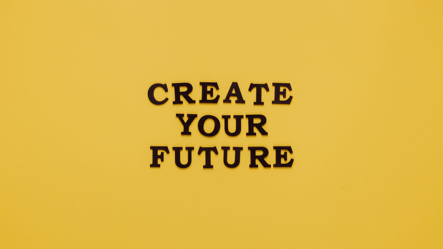 Napis CREATE YOUR FUTURE na żółtym, minimalistycznym tle