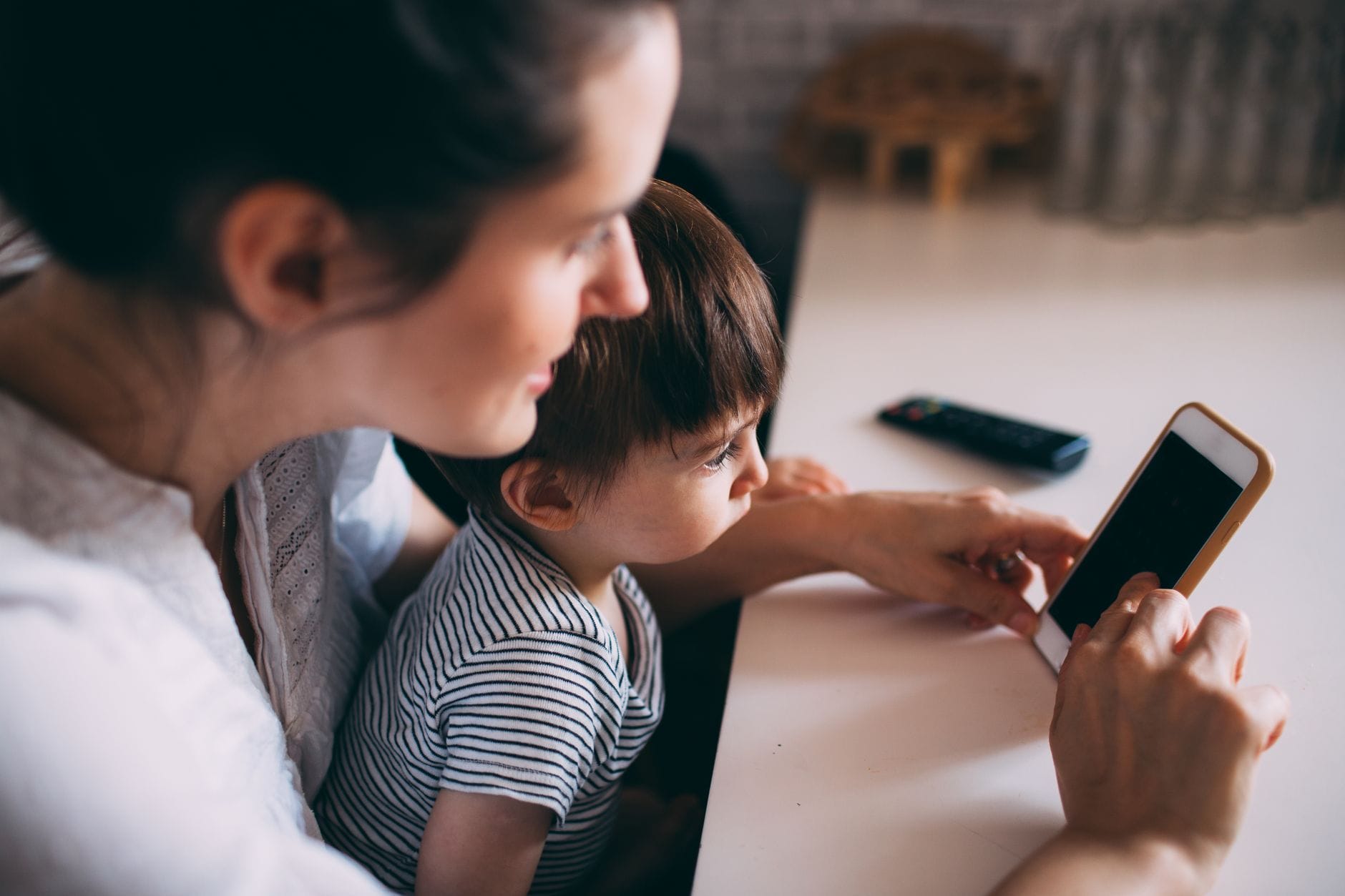 Dziecko i social media: jak uczyć odpowiedzialności bez straszenia i zakazów Mama z dzieckiem wspólnie korzystają ze smartfona w domu