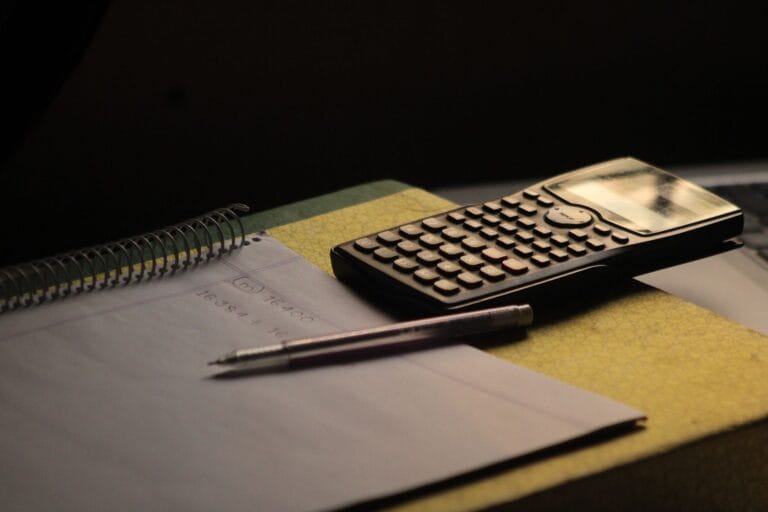 Kalkulator i notatnik na biurku do nauki matematyki maturalnej